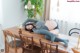 A woman laying on top of a wooden table.