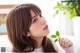 A woman holding a green plant in her hand.