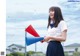 A woman in a school uniform holding a red and blue megaphone.