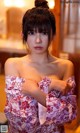 A woman in a red and white kimono posing for the camera.