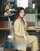 A woman sitting at a desk talking on a cell phone.