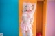 A woman in a pink and white outfit standing in front of a locker.