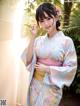 A woman in a blue and pink kimono posing for a picture.