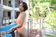 A woman in an orange bathing suit standing next to a pool.