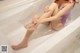 A woman sitting in a bathtub with her legs crossed.