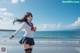 A woman in a school uniform running on the beach.